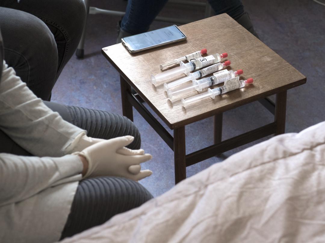 Op een klein tafeltje ligt een rij injectiespuiten.