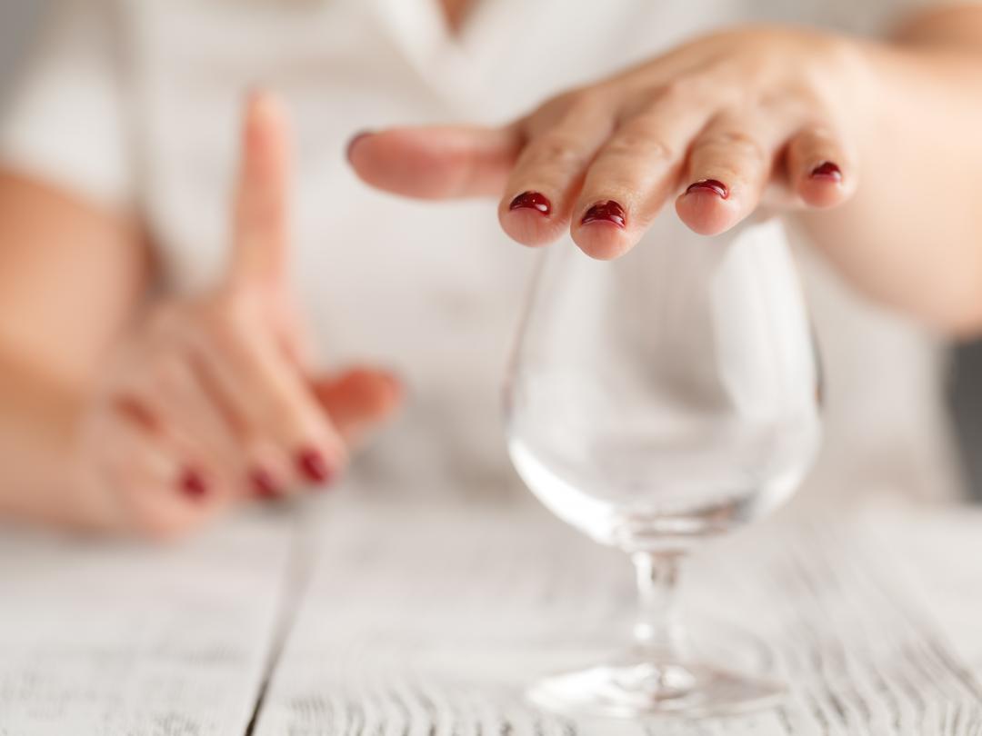 Hand op een glas wijn