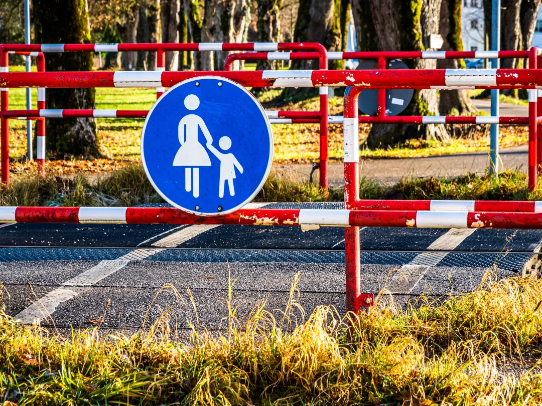 Een hek met een verkeersbord met moeder met kind