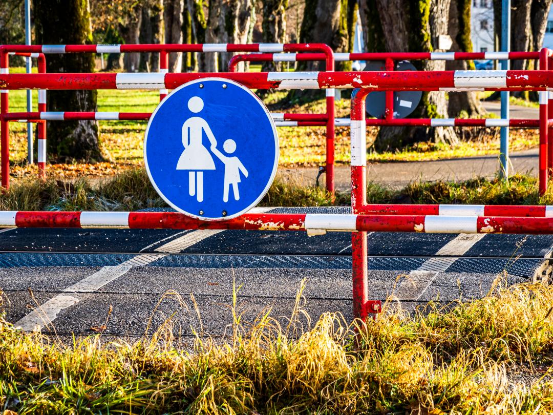 Een hek met een verkeersbord met moeder met kind