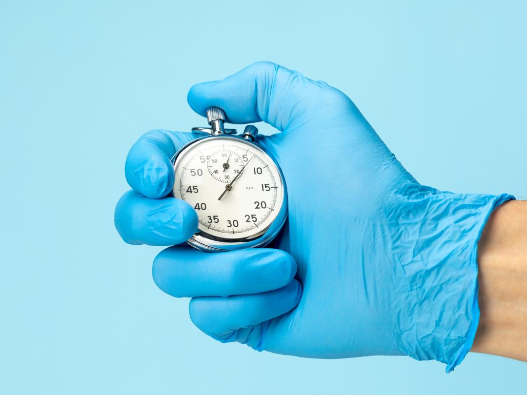 Gehandschoende hand met stopwatch