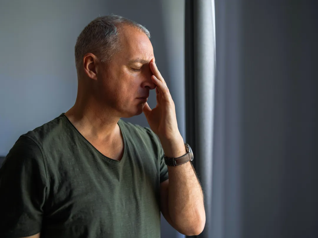 Man met hand tegen het hoofd