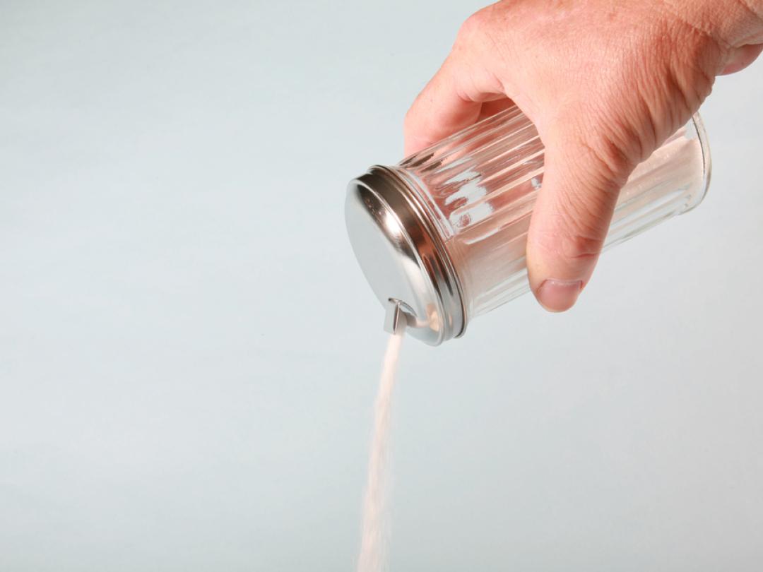 Iemand die een suikerstrooier leeg gooit