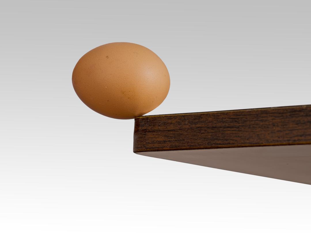 Een ei dat van een tafel dreigt te vallen