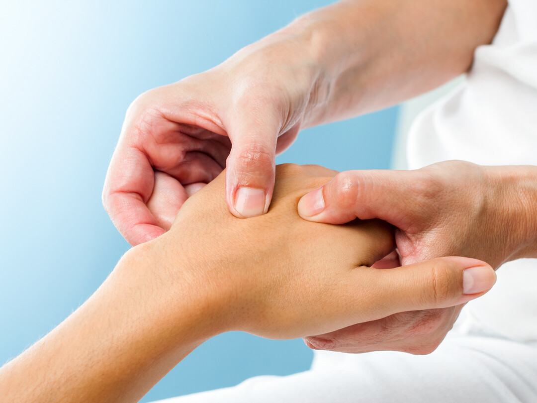 Iemand die een hand onderzoekt