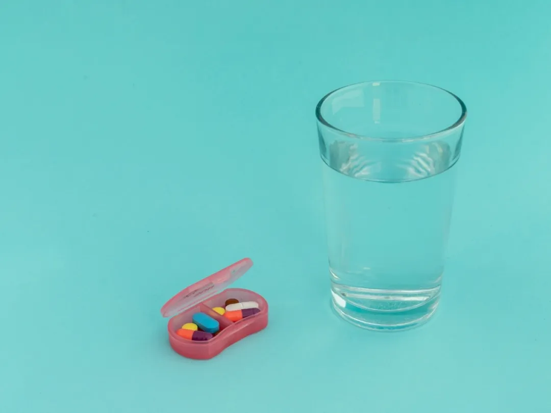 Glas water met een pillendoosje