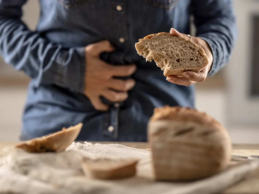 Iemand met brood in zijn hand die buik vasthoudt