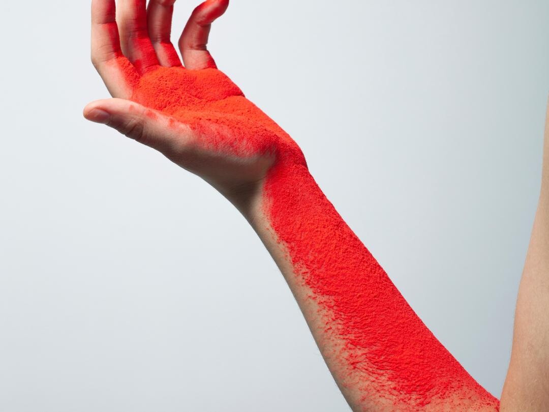 Arm bedekt met rood poeder