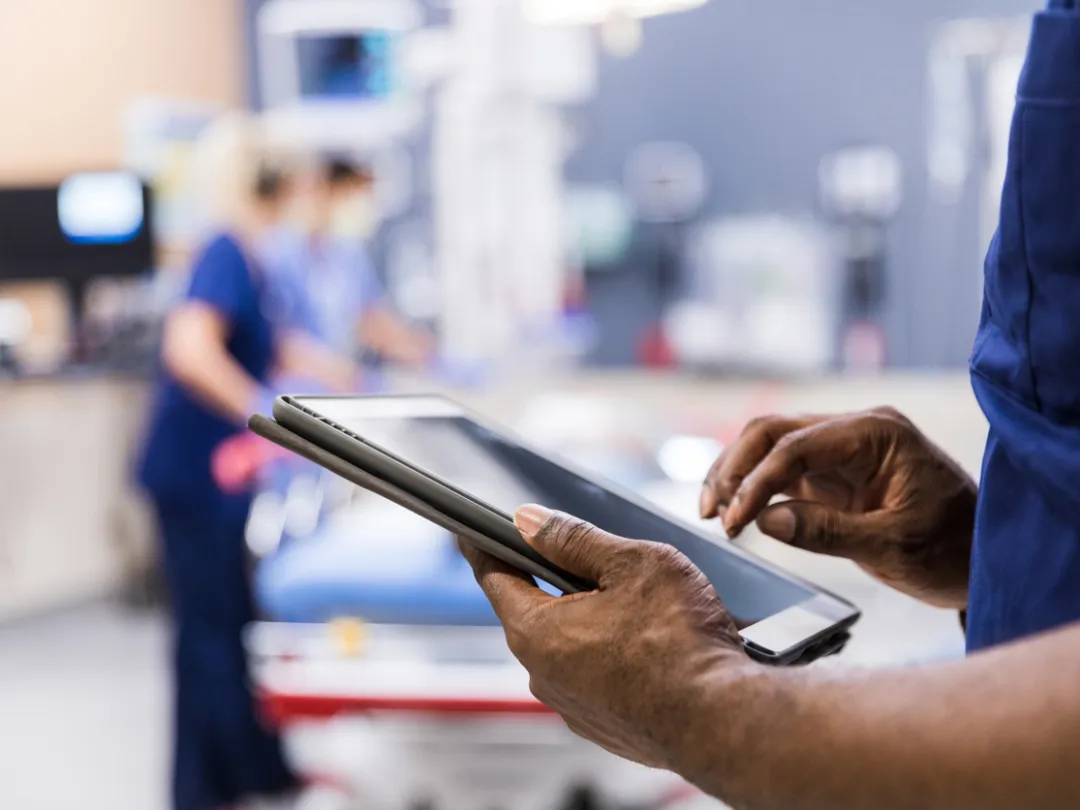 Beeld van een persoon met een tablet in de hand