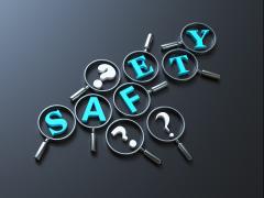 Het woord 'Safety' omringd door vraagtekens. Op elke letter en vraagteken ligt een vergrootglas.