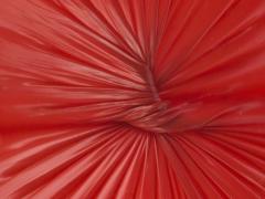 Een knoop in rood, latexachtig materiaal.