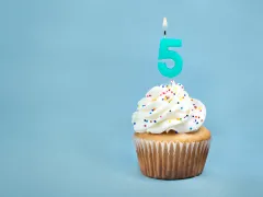 Een cupcake met een kaarsje in de vorm van het cijfer 5.