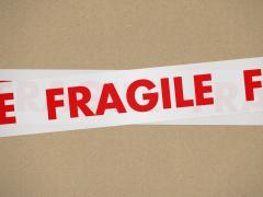 Close-up van een sticker met het woord 'FRAGILE' op een stuk karton.