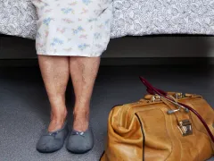 Oude dame op een bed