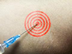Een naald prikt in een bulls-eye getekend op iemands huid.