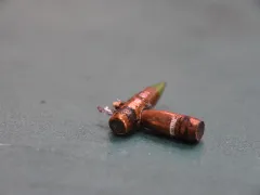 Twee kogels waarvan de een de ander heeft doorboord.