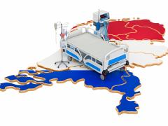 Plattegrond van Nederland in rood-wit-blauw. Bovenop staat een ziekenhuisbed.