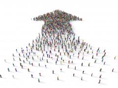 Een massa mensen vormt samen een pijl.