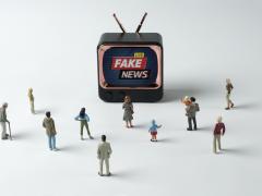 Kleine miniatuur tv met miniatuurfiguren eromheen.