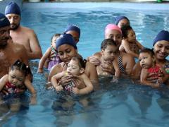 Zwemmende kinderen met hun ouders