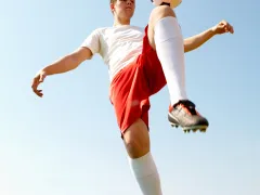 Kind met voetbal op de knie
