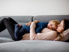Moeder en kind liggend op de bank