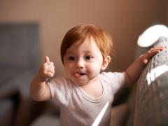 Baby die duim omhoog houdt