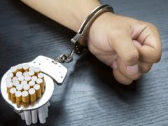 Hand en Sigaretten vast in handboeien