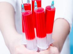 Handjevol injectiespuiten met rode vloeistof