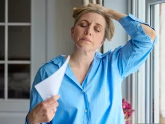 Vrouw met ogen dicht en hand op haar hoofd