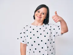 Vrouw met downsyndroom die duim omhoog houdt