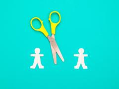 Illustratie van twee poppetjes met een schaar ertussen
