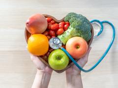 Een hart bestaande uit groent en fruit met een stethoscoop erop