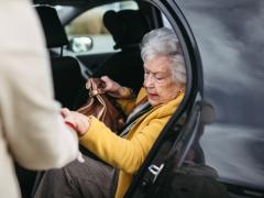 Oude vrouw stapt uit auto