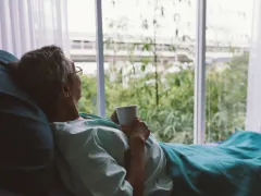 Iemand die vanuit een ziekenhuisbed naar buiten kijkt
