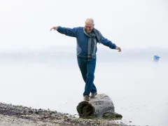 Man die balanceert op een boomstam
