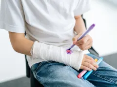 Iemand die tekent op zijn gips