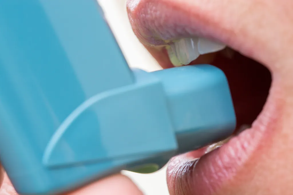 Een inhalator aan een mond.