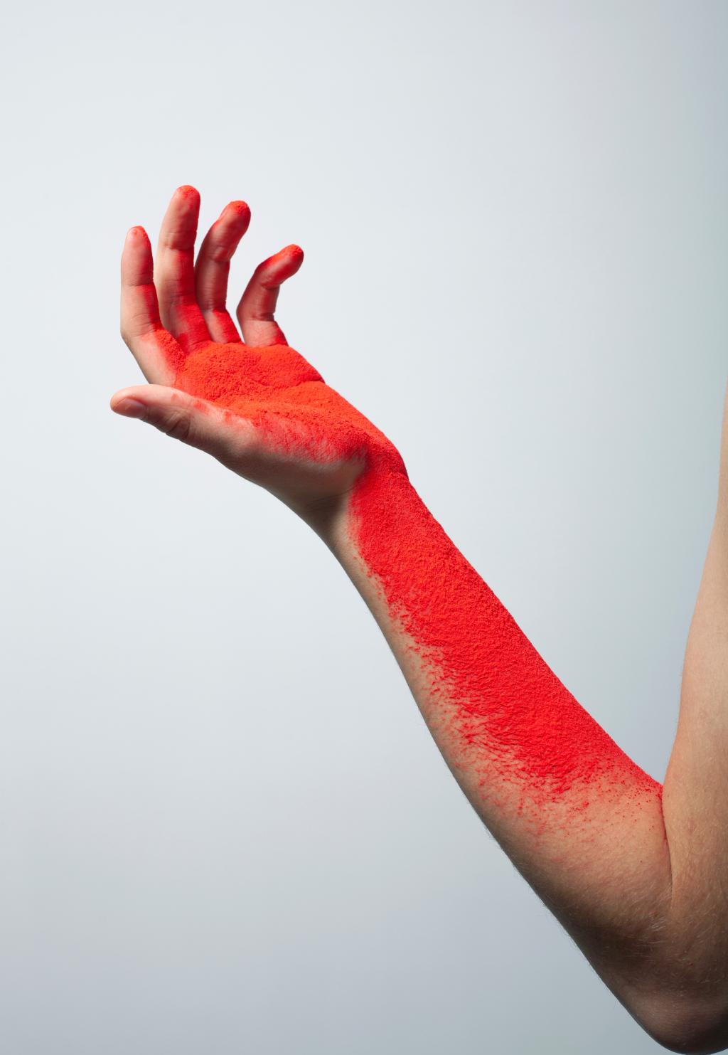Foto van een arm met rode inkt