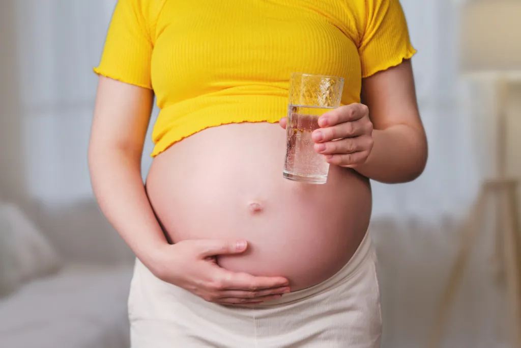 Zwangere vrouw met glas water 